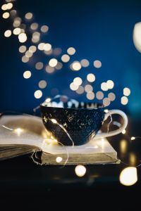 Cup of coffee, book, fairy lights