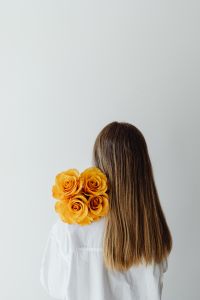 Kaboompics - Young girl with long blonde hair holds orange roses