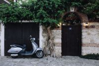 Scooter parked next to the door on an old street in Nessebar, Bulgaria