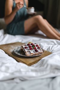 Beautiful young woman having breakfast in the bed
