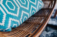 Closeup of blue pillow and rattan chair