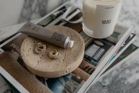 Kaboompics - Contemporary UGC Style Still Life: Hand Cream and Elegant Earrings on a Travertine Tray Over a Marble Surface