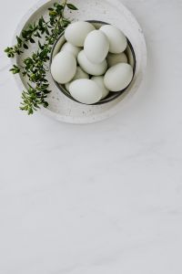 Easter flat lay with green eggs on a white marble