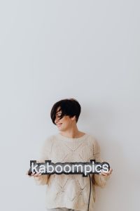 Kaboompics - The woman is holding the Kaboompics neon in her hands