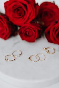 Kaboompics - Red roses and gold rings on white marble