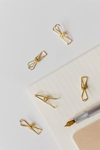 Fountain pen, clips and notebooks on a white desk