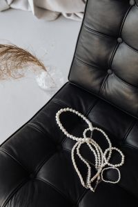Pearl necklaces - jewelry - black leather chair - Ludwig Mies van der Rohe - Lounge chair - Barcelona chair