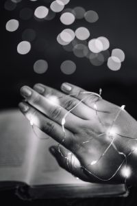 Kaboompics - Female hand, fairy lights, book