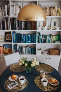 Kaboompics - Round breakfast table with white flowers by the bookcase