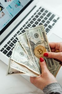 The woman holds a Cryptocurrency Bitcoin & US Dollars