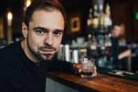 Kaboompics - Handsome young man having a whiskey in a pub