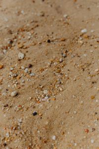 Kaboompics - Sand beach background with sea shells & pebbles - many round small stones