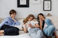 Kaboompics - Teens sit together on the couch and use phones