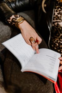 Kaboompics - A woman with a large ring and a golden watch writes down in the calendar