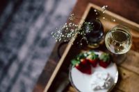 Kaboompics - Strawberries with cream and glass of white wine on wooden tray