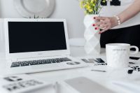 Kaboompics - Woman, yellow flowers in a vase, white laptop, cup, desk