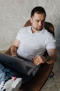 Kaboompics - The man is sitting in a chair and working with a laptop