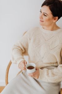 Kaboompics - A woman in a warm sweater drinks tea
