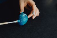 Woman Painting Blue Easter Eggs