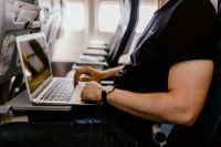 Kaboompics - Unrecognizable man with notebook sitting inside an airplane