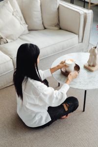Kaboompics - An Asian adult woman lights a candle - marble table