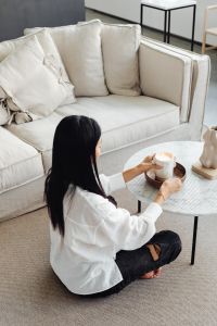 Kaboompics - An Asian adult woman lights a candle - marble table