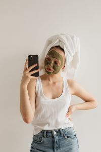 Kaboompics - Young Girl with Clay Mask on Her Face Taking a Selfie