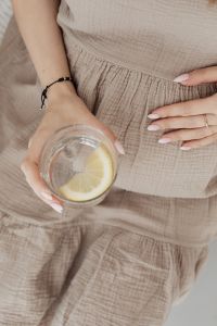 Pregnant woman drinks water with lemon