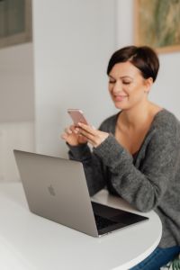 Kaboompics - A brunette woman works with a laptop and a phone