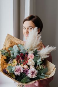 Kaboompics - A woman with a bouquet wrapped in paper