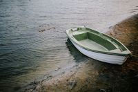 Kaboompics - Little green boat by the shore