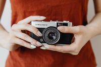 Kaboompics - Old film camera in the hand of a young woman