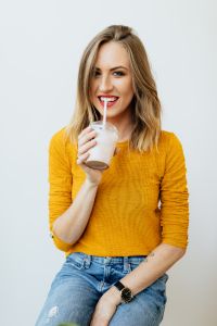 Kaboompics - A joyful young woman drinks a McDonald's milkshake