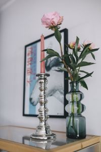 Kaboompics - Candle and a flower on a bookcase