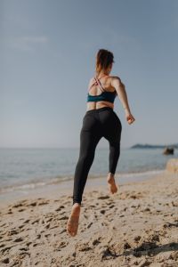 Woman jogging on the beach - running