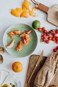 Orange - tomatos - bread -  cutting board ona table