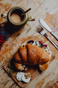 Croissant with goat cheese, beetroot and a cup of coffee for breakfast