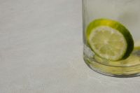 Tall glass with water - lime - ice cubes - close up - closeup