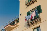Typical Italian balcony in an old house with drying laundry
