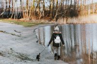 Woman walking the dog by a lake