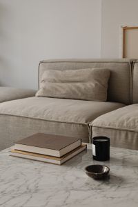 Kaboompics - Living room - gray beige sofa - marble coffee table - coffee table books - candle