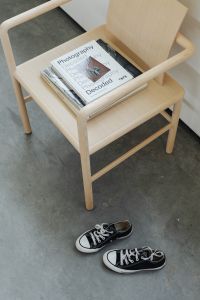 Kaboompics - Wooden minimalist chair - magazines and books - converse sneakers