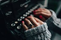 Kaboompics - Woman typing on an old typewriter