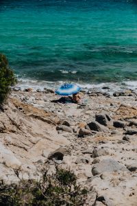 Kaboompics - A woman under an umbrella on the beach