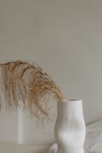 Dried palm leaf in a white vase