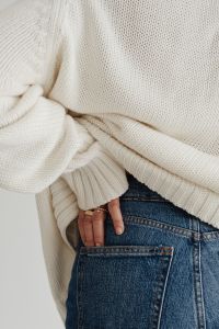 Woman in white sweater - gold rings - jewelry - jeans