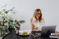 Kaboompics - A businesswoman drinks coffee and eats grapes at work