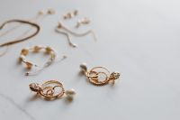 Gold jewellery on white marble - necklace, bracelets, earrings