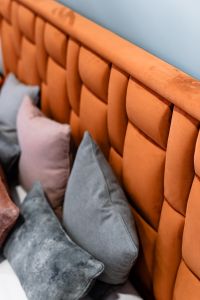 Kaboompics - Upholstered orange bed - pillows