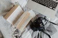 Kaboompics - A camera, MacBook, and a book waiting in bed